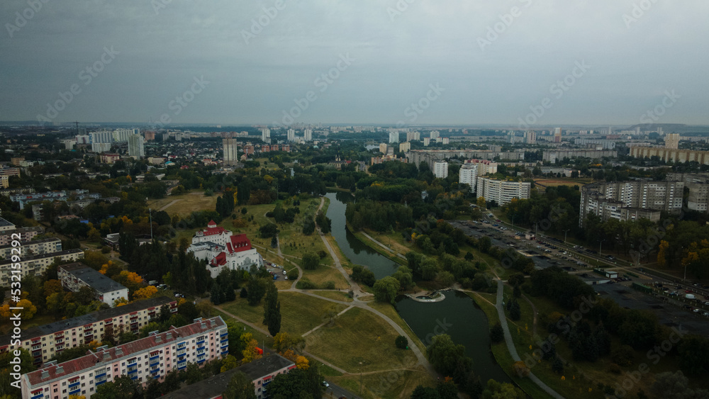 River in the city park. Multi-storey buildings with infrastructure. Densely populated urban area. Overcast weather. Aerial photography.