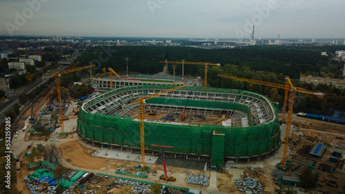 Building a stadium in a big city. Construction site among urban areas. Aerial photography. photo