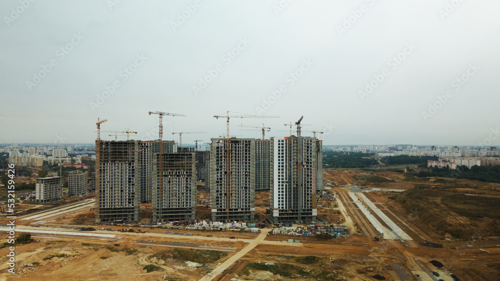 Obraz premium Construction site of a new city block. Construction of multi-storey buildings. Overcast weather. Aerial photography.