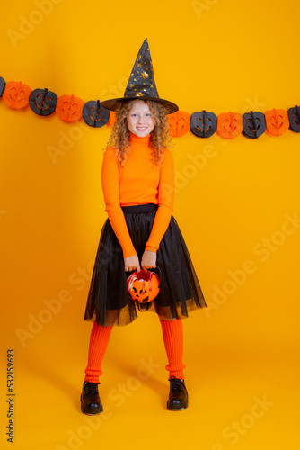 teenage girl in a witch costume on a yellow background , halloween © Olesya Pogosskaya