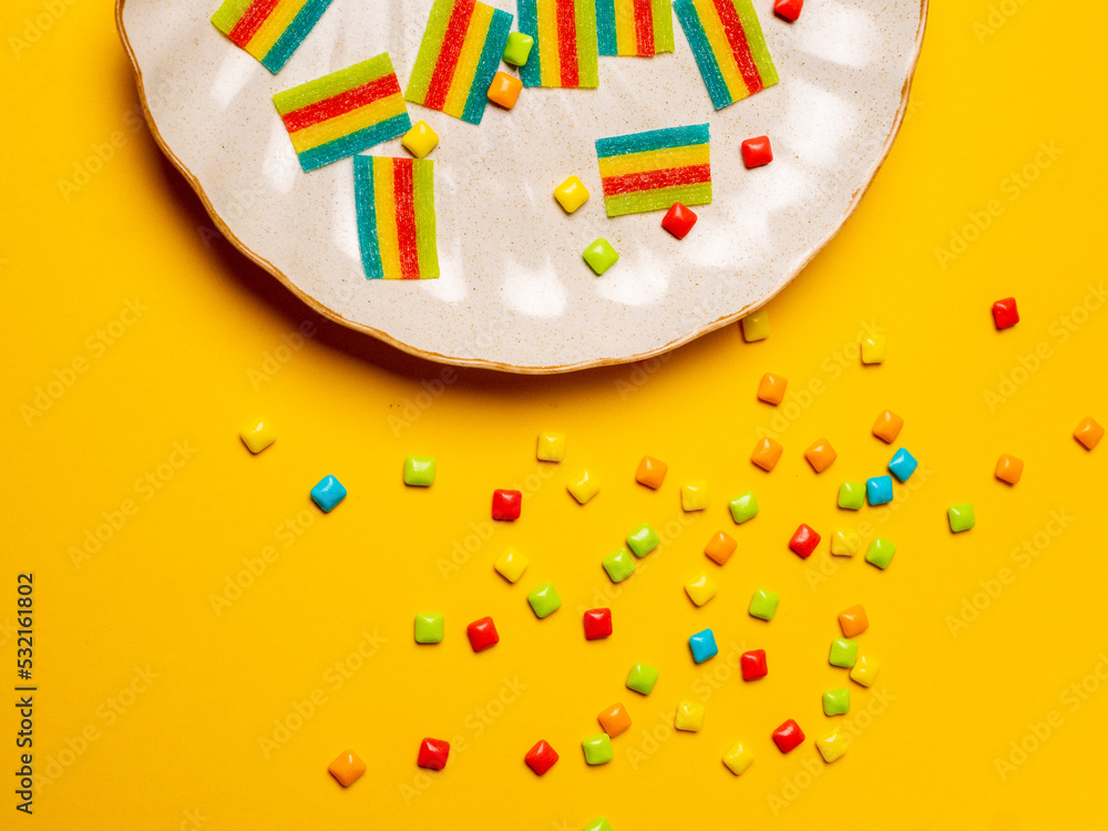 Multicolored marmalade sweets on a yellow background. 
