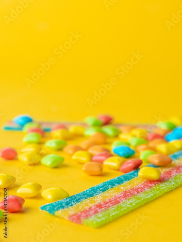 Multicolored marmalade sweets on a yellow background. Place for text 