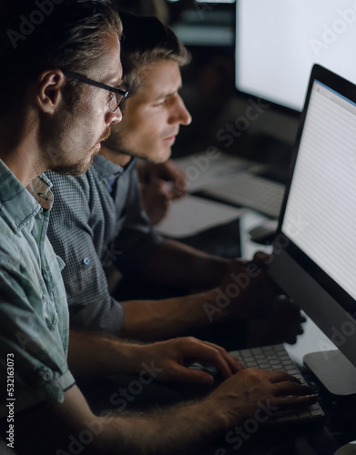 business team works on computers at night. photo