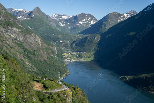 Wonderful landscapes in Norway. Vestland. Beautiful scenery of Geiranger Fjord from the Ornesvingen viewpoint. Cruise ship, winding roads, waterfall and stream. Summer sunny day. Selective focus