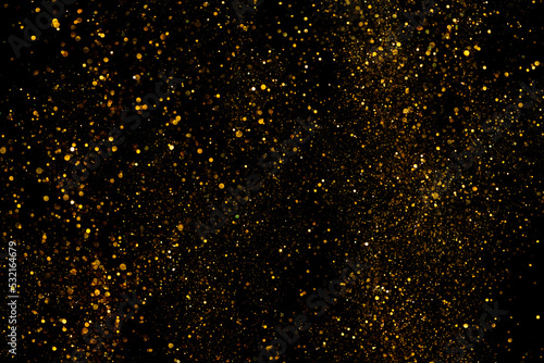 Golden glitter shiny dust particles glowing lights bokeh abstract background