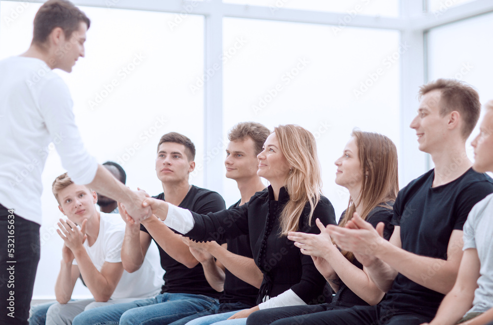 young people shaking hands at a group meeting. young people shaking hands at a group meeting.