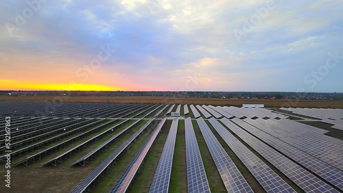 Aerial drone view into large solar panels at a solar farm at summer sunset. Solar cell power plants. footage HDR video 4k.
