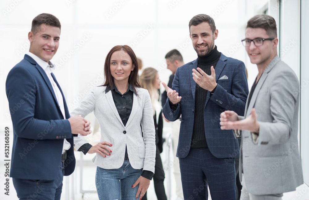 group of employees standing in the office applauding group of employees standing in the office applauding