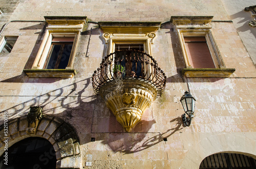 Il balcone con la ringhiera in ferro battuto e i fregi in pietra leccese in un palazzo storico di Corigliano d'Otranto photo