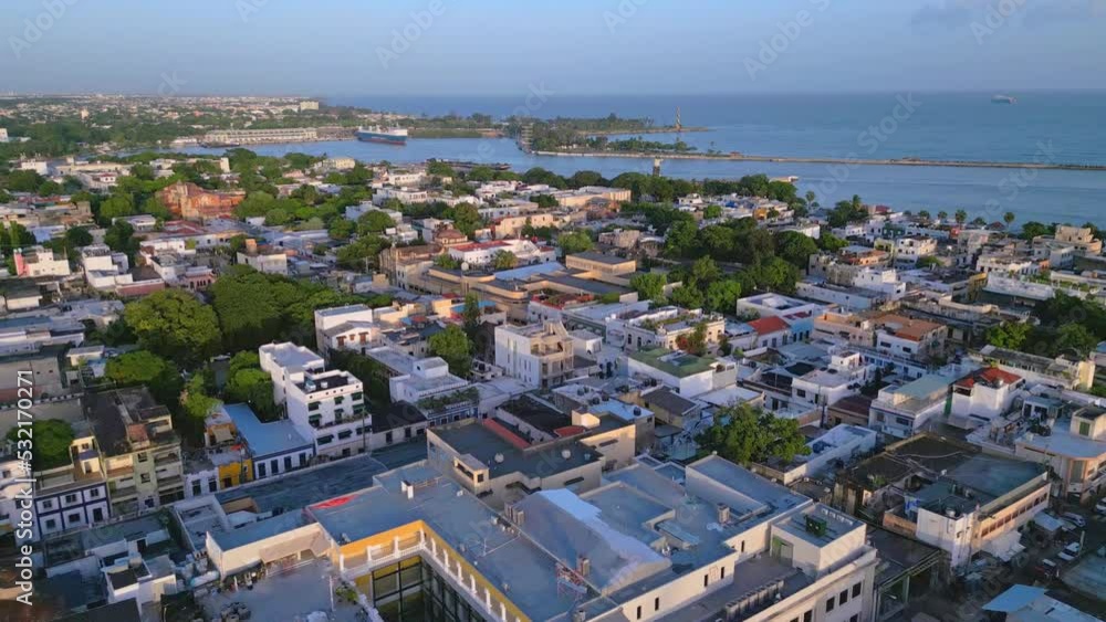 Aerial flyover city of Santo Domingo at colonial zone with harbor and ship in background at sunset Aerial flyover city of Santo Domingo at colonial zone with harbor and ship in background at sunset