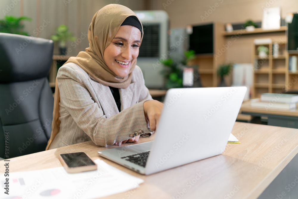 happy business muslim hijab woman work. islam woman pointing at laptop screen while having an online group meeting. success cheerful adult beautiful arabic person sitting touch screen consult people happy business muslim hijab woman work. islam woman pointing at laptop screen while having an online group meeting. success cheerful adult beautiful arabic person sitting touch screen consult people