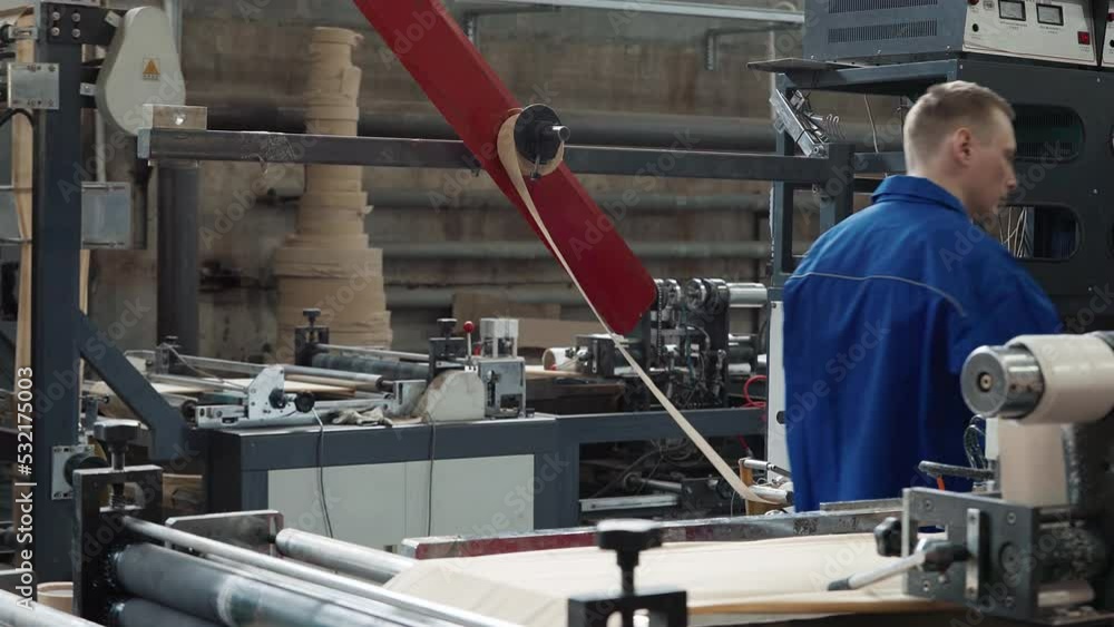 Strip Of Eco Fabric Coiled On Automated Manufacturing Equipment Supervised By Worker. Fabric Stretching On Mechanisms Of Manufacturing Equipment. Environment Friendly Fabric Manufacturing Equipment Strip Of Eco Fabric Coiled On Automated Manufacturing Equipment Supervised By Worker. Fabric Stretching On Mechanisms Of Manufacturing Equipment. Environment Friendly Fabric Manufacturing Equipment