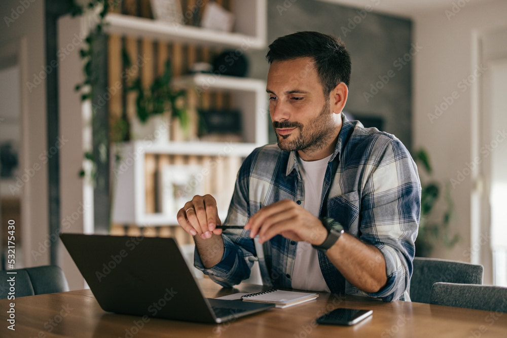 Obraz premium Focused adult man having a business meeting, using a laptop, at