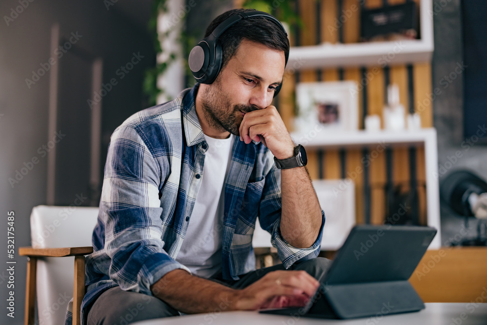 Businessmen working over the tablet, having an online meeting, using headphones. Businessmen working over the tablet, having an online meeting, using headphones.