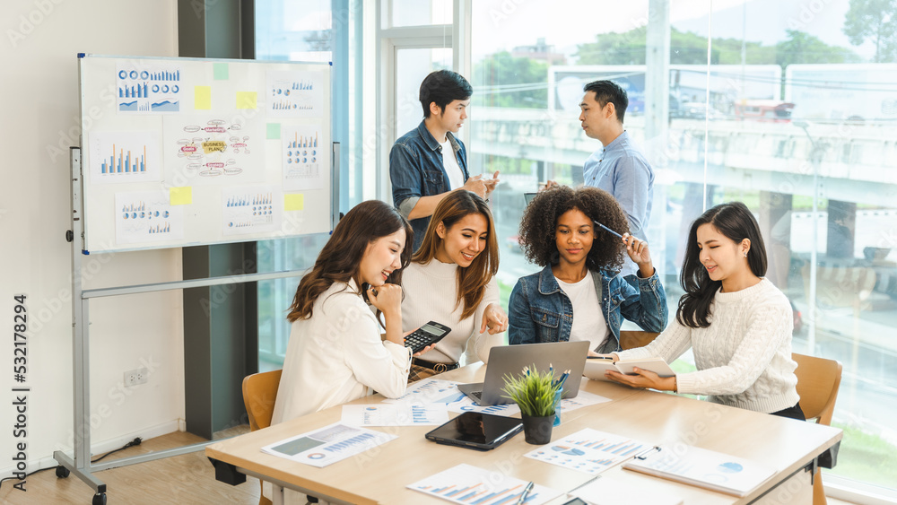 Young and successful mixed race, asian business people working on project together, sitting at table in boardroom. Young and successful mixed race, asian business people working on project together, sitting at table in boardroom.