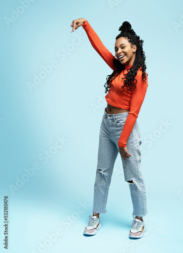 Fényképezés Cheerful Afro woman points away on copy space, discusses amazing promo isolated