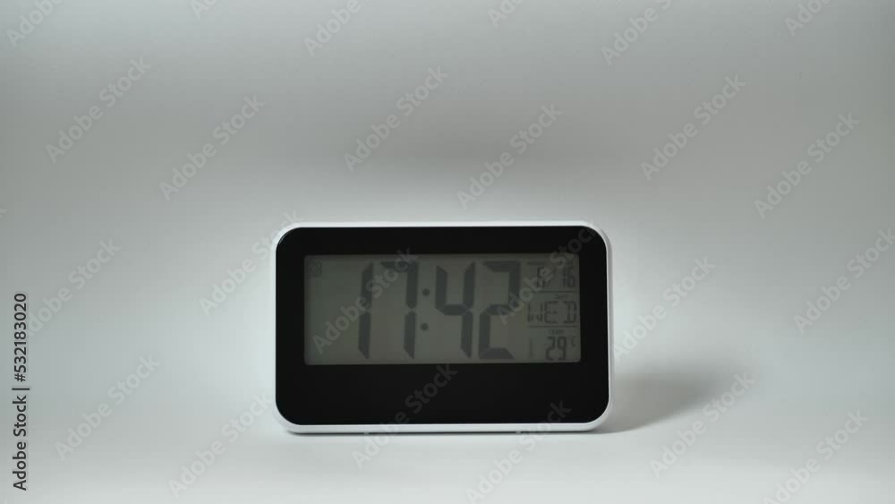 Modern mirror clock, alarm clock with a thermometer, hydrometer standing on white background. Time concept. Modern mirror clock, alarm clock with a thermometer, hydrometer standing on white background. Time concept.