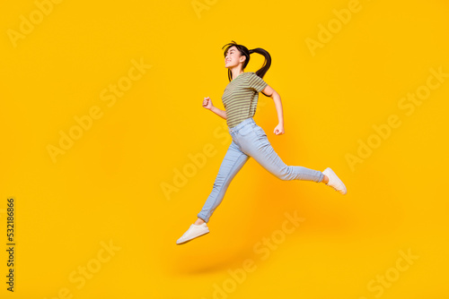 Full length profile side photo of charming girl running enjoy her summer trip isolated on yellow color background