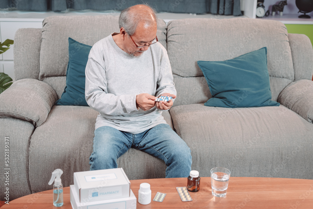 Fototapeta premium Asian senior elderly male patient on eating pill recover self at nursing home care. old man wearing glasses reading prescription and content. Medical insurance concept