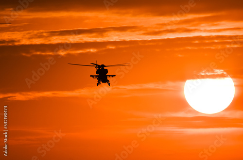 Helicopter flying at sunset, silhouette