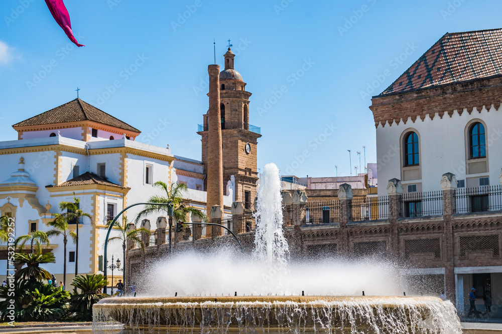 Selective focus on water flowing from fountain and drops, and Santo Domingo Convent in the background with tower