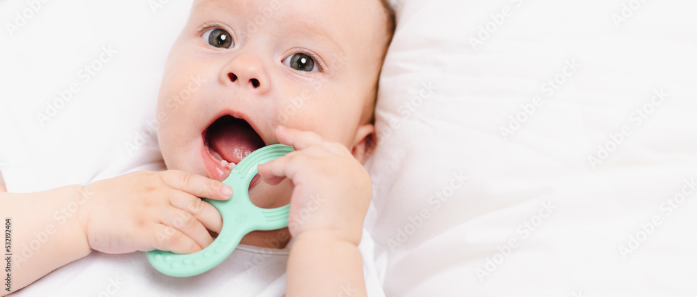 A baby with a teether on a white background . Teething. Children's article. A baby with a teether on a white background . Teething. Children's article.