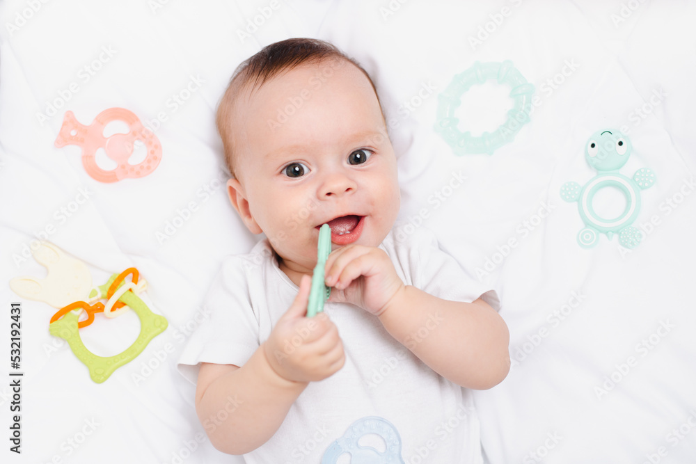 A baby with a teether on a white background . Teething. Children's article. A baby with a teether on a white background . Teething. Children's article.