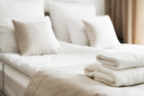 White fresh towels on bed in hotel room photo