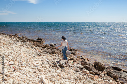 Girl collects driftwood on the seashore