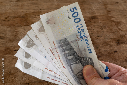 Copenhagen, Denmark A hand with 500 krone notes. photo