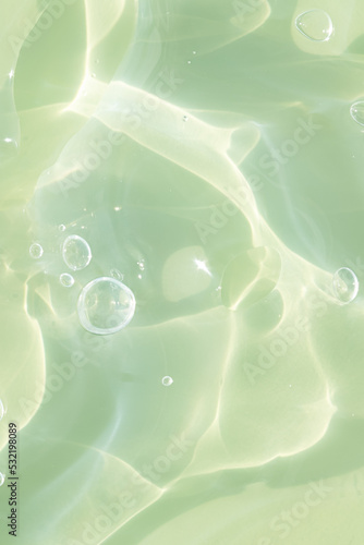 The texture of a green gel or serum with hyaluronic acid for the face. Cosmetic transparent liquid cream with oxygen bubbles. Wellness and beauty concept. Sanitizer, virus protection.