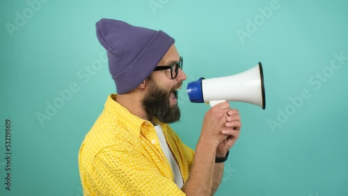 Funny emotional guy with megaphone, talking proclaiming news, loudly announcing advertisement, hot news announce discounts sale hurry up communication concept. Studio video isolated on blue background