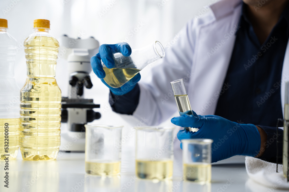 Quality control in oil refining industry concept. Male chemist hold test tube with yellow liquid biological research closeup. Quality control in oil refining industry concept. Male chemist hold test tube with yellow liquid biological research closeup.