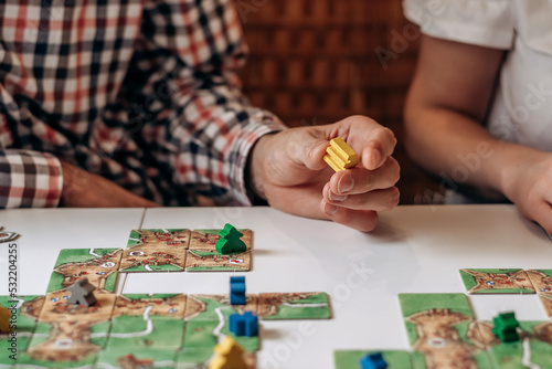 A group of young people play board games at home in the kitchen.Hands close-up.Time together.Stay home,board games concept.Selective focus.