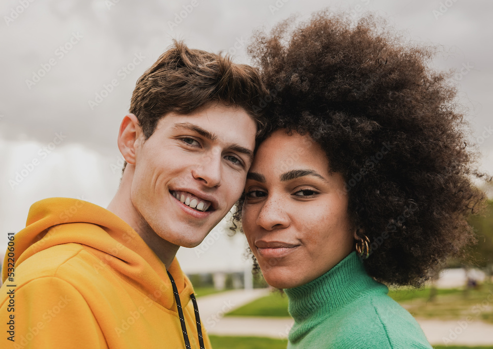 Young multiethnic couple smiling on camera Young multiethnic couple smiling on camera