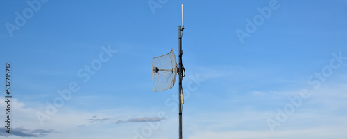 Outdoor repeater and receiver internet wifi service on metal pole which installed on the roof of the building to receive and transmit internet signal to users nearby, soft and selective focus.
