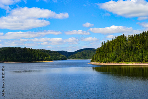 dam inbetween a forest in germany with blue sky and clouds