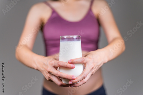 Pregnant woman giving a glass of milk, Pregnant woman with big belly on third trimesters of pregnancy, Drinks for health concept, Focus on a glass of milk. © Traiphop