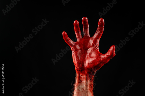 Male palm stained with blood on a black background.