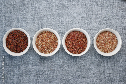 four different types of rice in a bowl on gray background 
