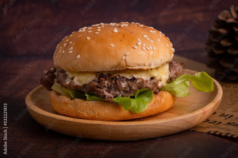 homemade hamburgers of beef, cheese and vegetables on an old wooden table. Fat unhealthy food close-up.