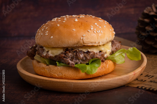 homemade hamburgers of beef, cheese and vegetables on an old wooden table. Fat unhealthy food close-up.