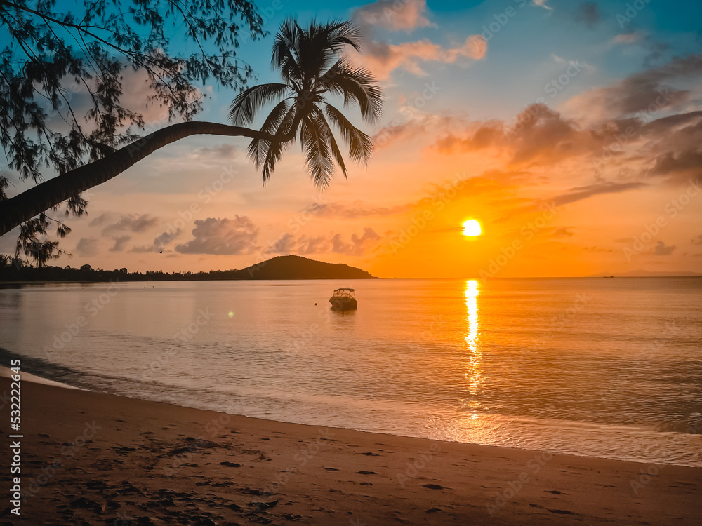 Bright sunset tropical beach, calm sea water, sand beach, fishing boat silhouette in orange sun light. Palm tree, sunrise colorful background. Amazing island landscape. Resort vacation, travel concept