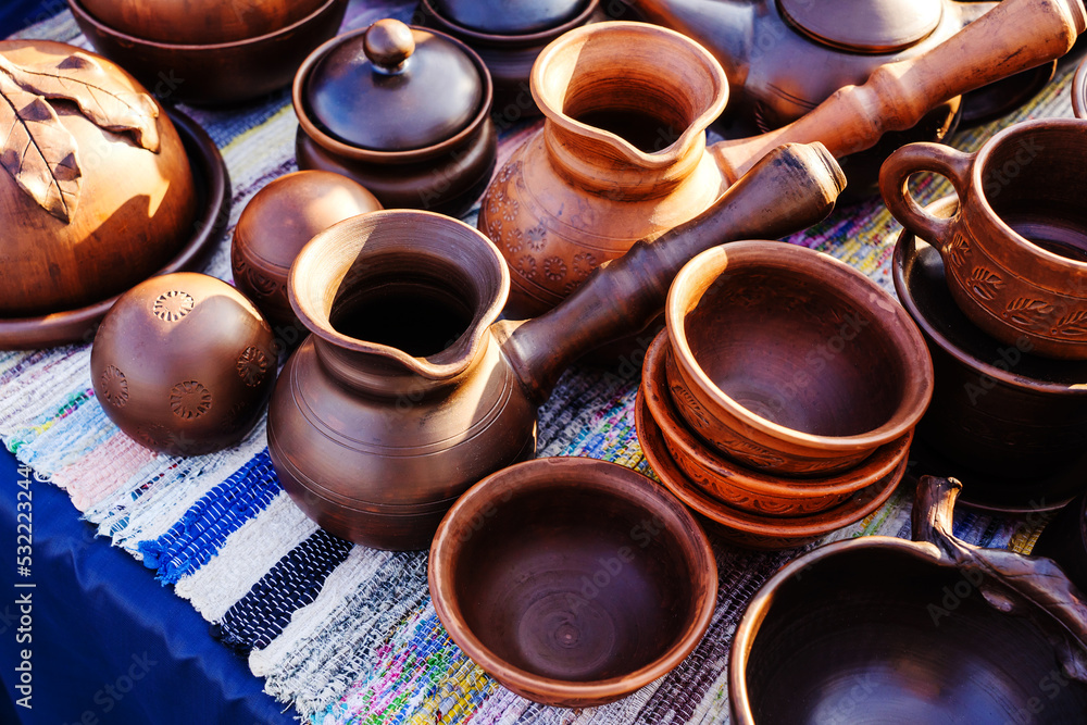 Clay jugs and plates in retro style. Ceramic products in a pottery workshop. Close-up Clay jugs and plates in retro style. Ceramic products in a pottery workshop. Close-up