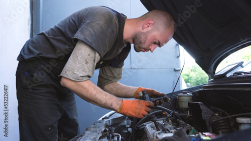 auto mechanic repairs car engine. car service. close-up. © metr1c
