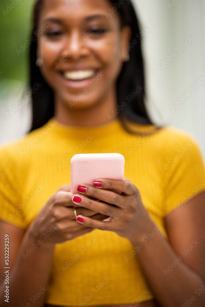 Happy black woman messaging using cell phone Happy black woman messaging using cell phone