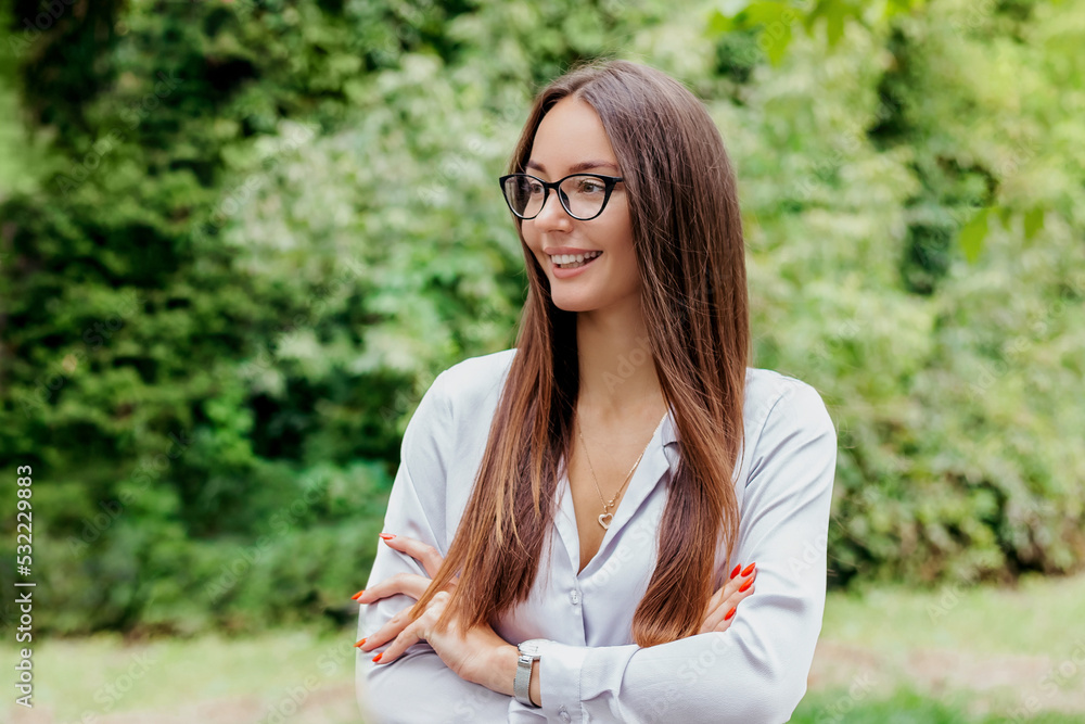 smiling brunette girl in glasses against the background of nature copy space smiling brunette girl in glasses against the background of nature copy space