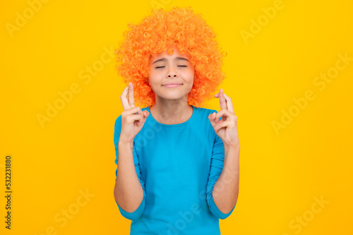 Teenage girl with yellow wig. Funny child wearing orange curly wig hair.