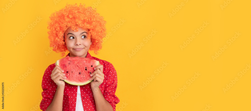 happy child in fancy orange hair wig hold fresh ripe water melon slice fruit, organic food. Summer girl portrait with watermelon, horizontal poster. Banner header with copy space. happy child in fancy orange hair wig hold fresh ripe water melon slice fruit, organic food. Summer girl portrait with watermelon, horizontal poster. Banner header with copy space.