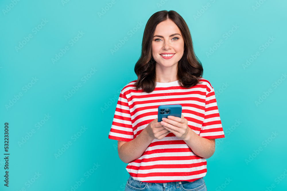 Photo of adorable sweet girl dressed red t-shirt typing modern gadget empty space isolated teal color background Photo of adorable sweet girl dressed red t-shirt typing modern gadget empty space isolated teal color background